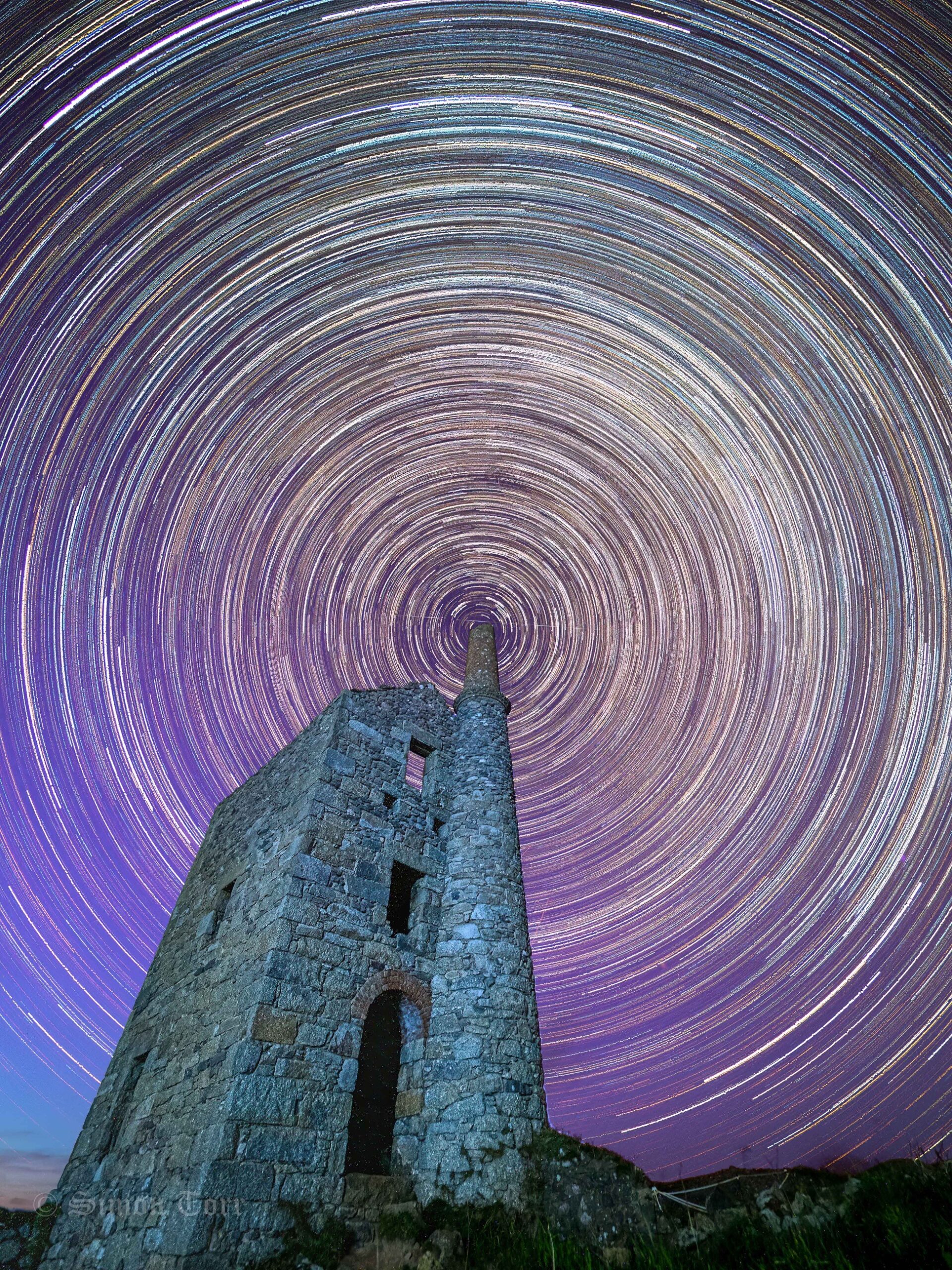 Star trails forming circles of light around chimney of Cornish Engine House