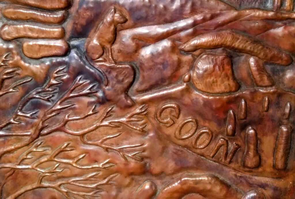 Detail of the side panel of Drolla - The Storytelling Bench showing Cornish landscape and animals